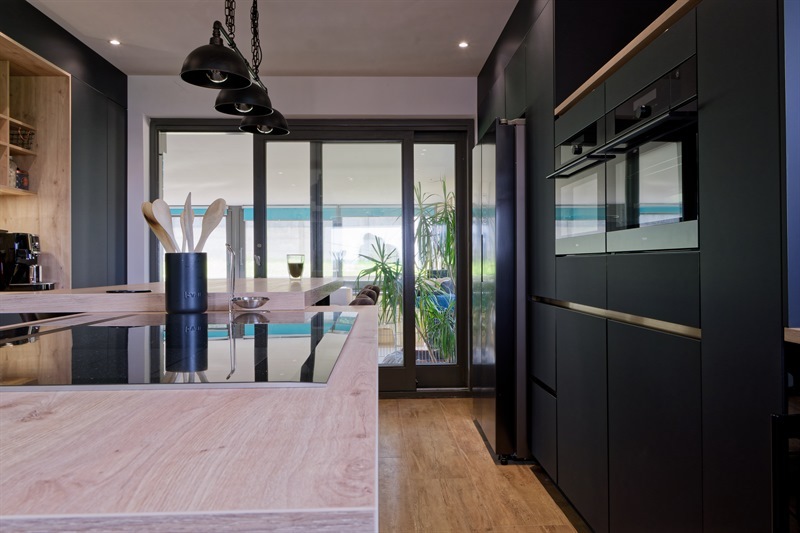 Cuisine ouverte de style industriel bois et noir à Arsimont | Raison Home - 2