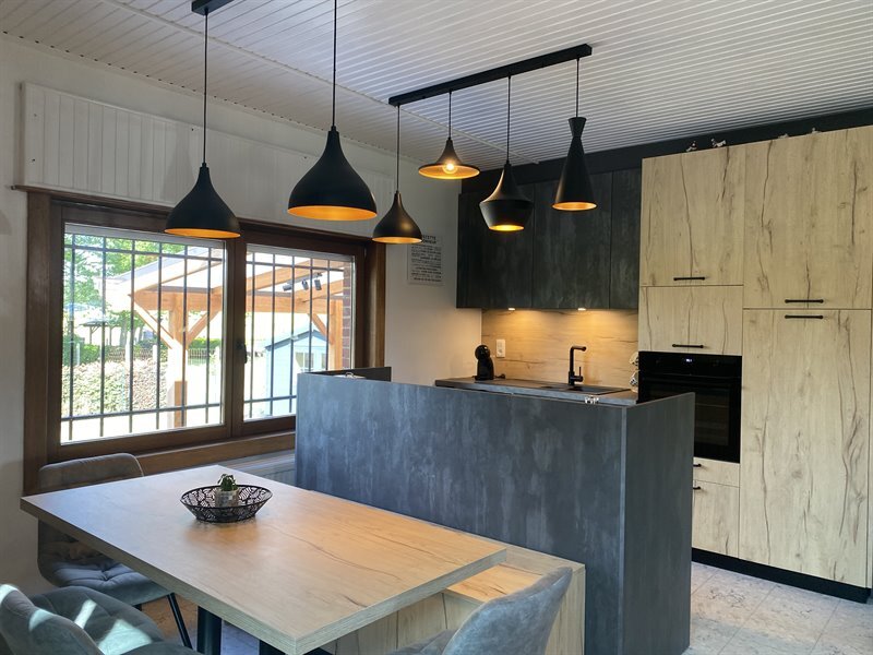 Cuisine ouverte de style industriel bois et gris à Harveng | Raison Home - 3