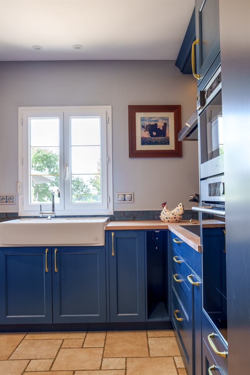 Cuisine ouverte de style campagne bleu à Dame Marie Les Bois | Raison Home - 4