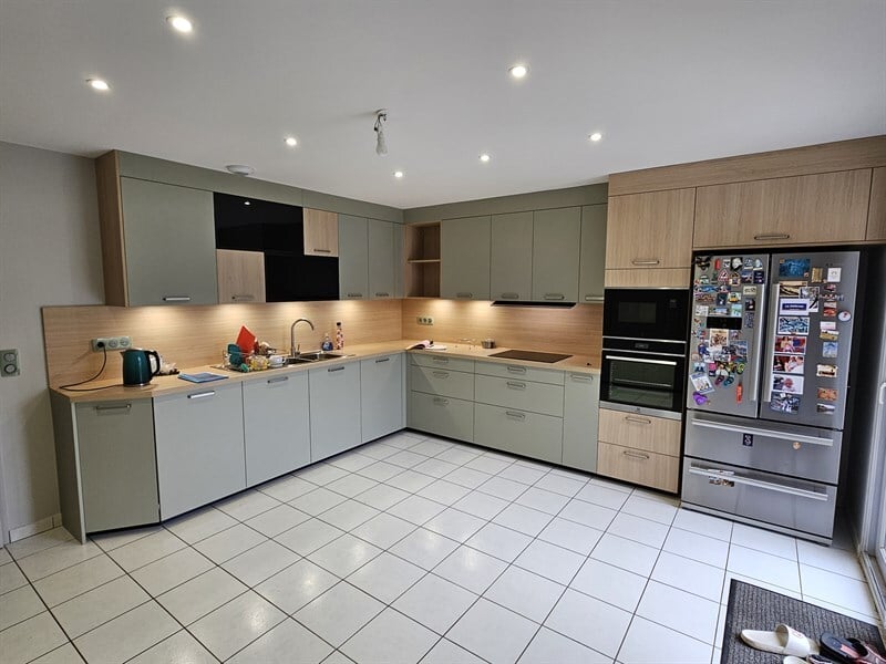 Cuisine en U et rangements jusqu'au plafond bois et vert à Heillecourt | Raison Home - 1